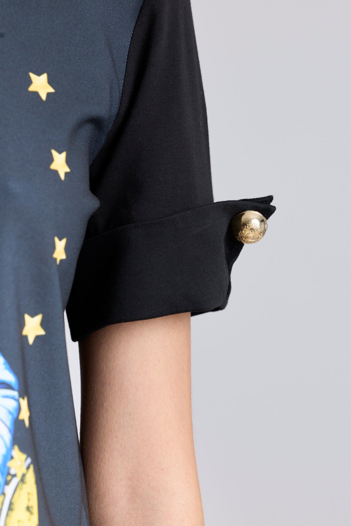 Camiseta negra con botones dorados en las mangas y estampado de tigre con boina azul de The Extreme Collection.