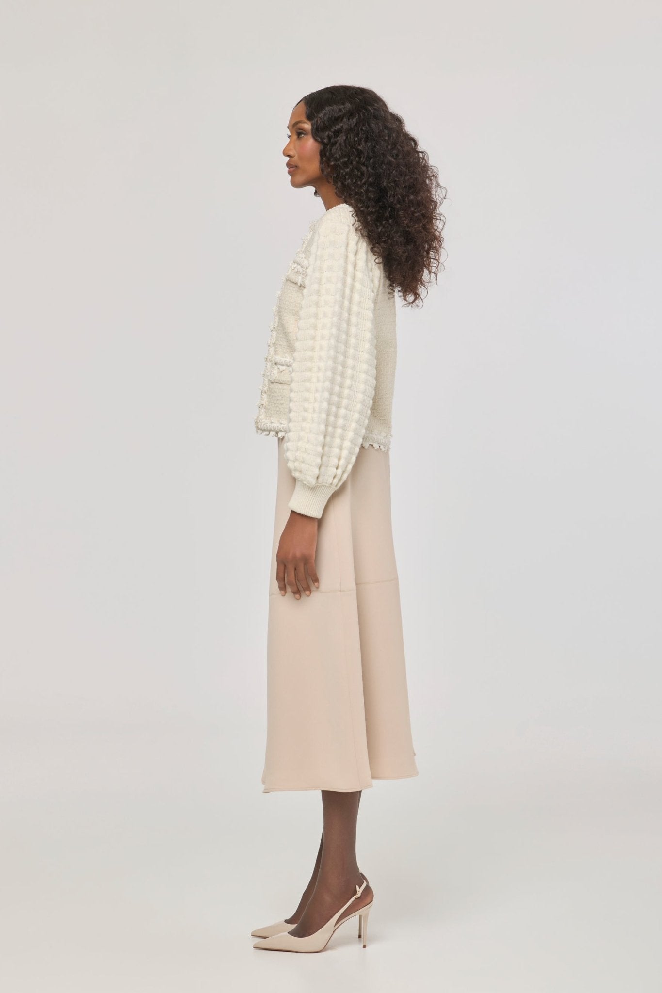 Cárdigan estructurado blanco de punto para mujer con estética estilo tweed, mangas abullonadas y ribetes detallados.