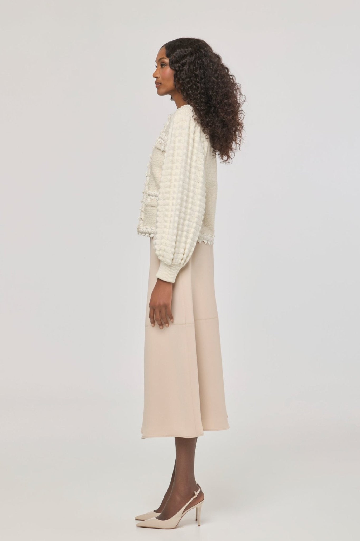 Cárdigan estructurado blanco de punto para mujer con estética estilo tweed, mangas abullonadas y ribetes detallados.
