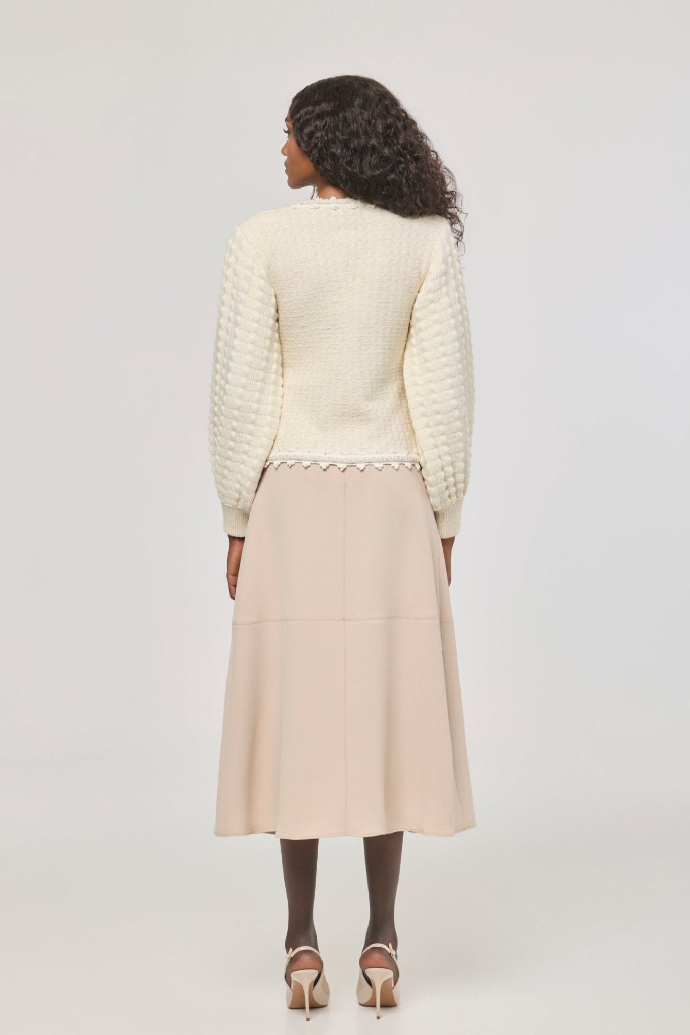 Cárdigan estructurado blanco de punto para mujer con estética estilo tweed, mangas abullonadas y ribetes detallados.