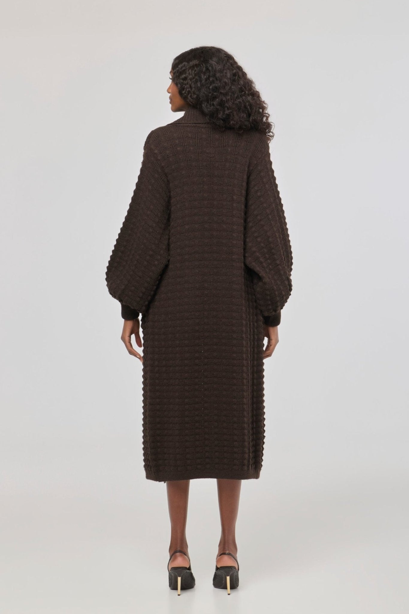 Cárdigan largo marrón de punto para mujer con mangas de textura geométrica y diseño minimalista.