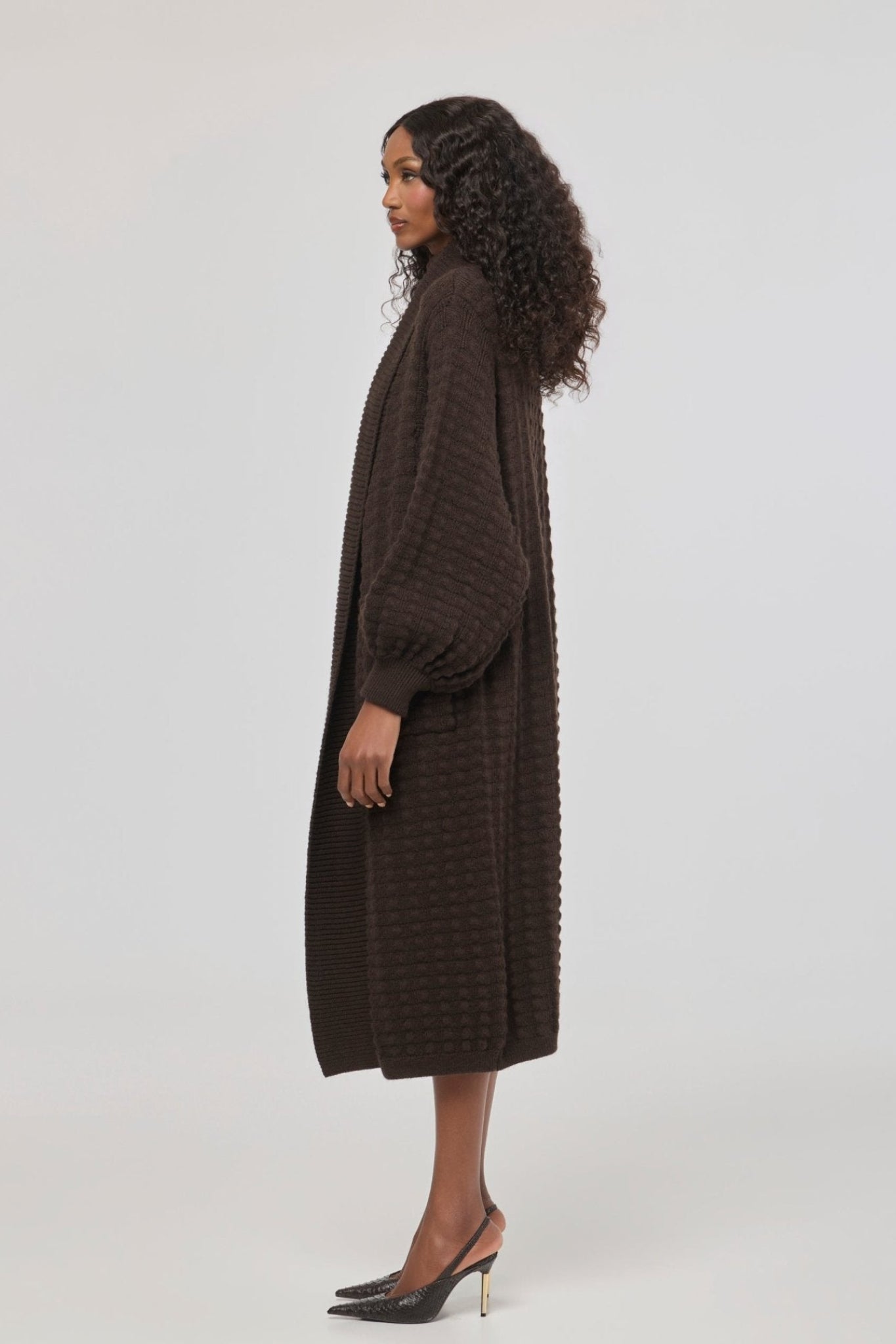 Cárdigan largo marrón de punto para mujer con mangas de textura geométrica y diseño minimalista.