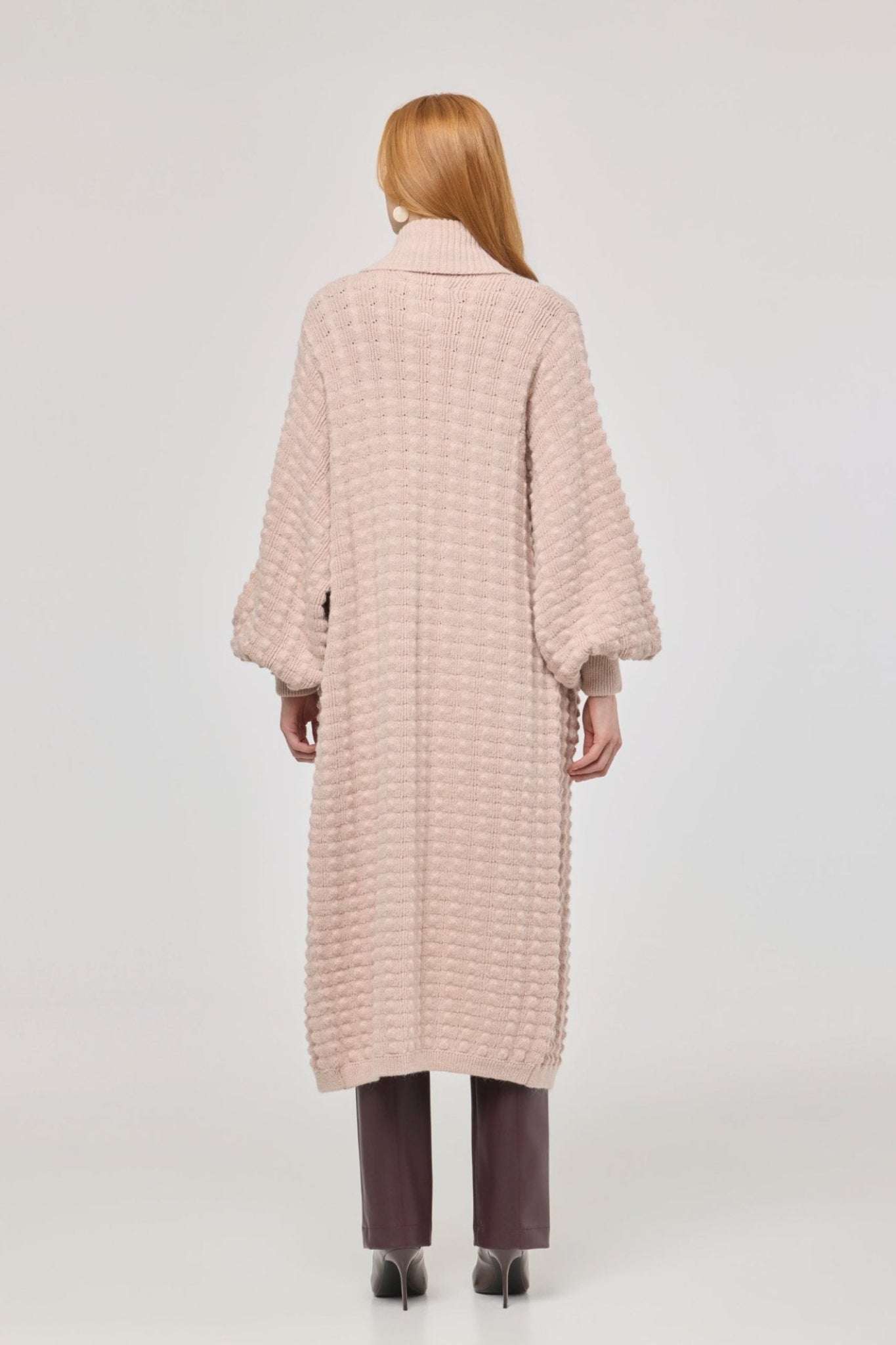 Cárdigan largo rosa de punto para mujer con mangas de textura geométrica y diseño minimalista.