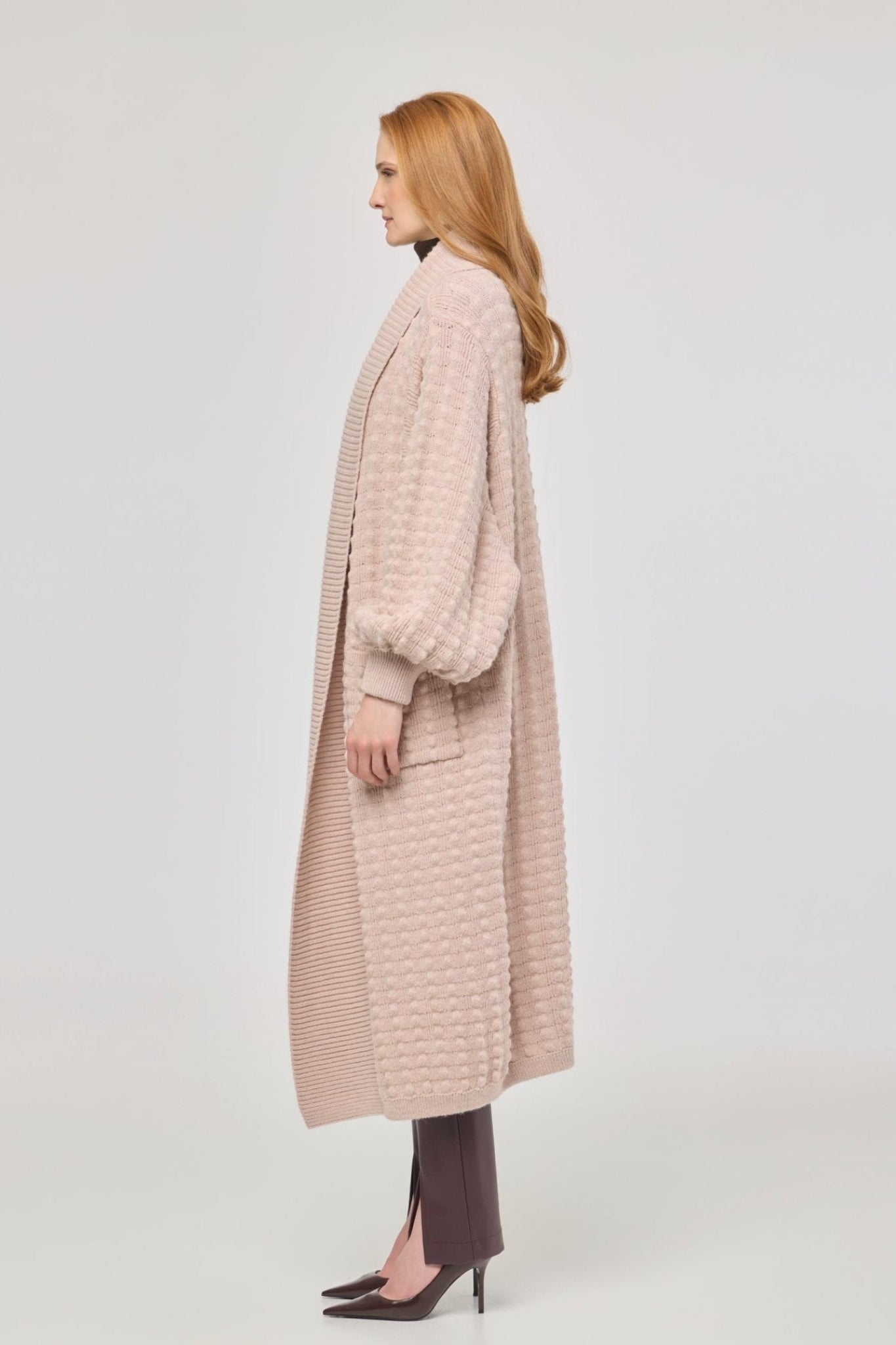 Cárdigan largo rosa de punto para mujer con mangas de textura geométrica y diseño minimalista.