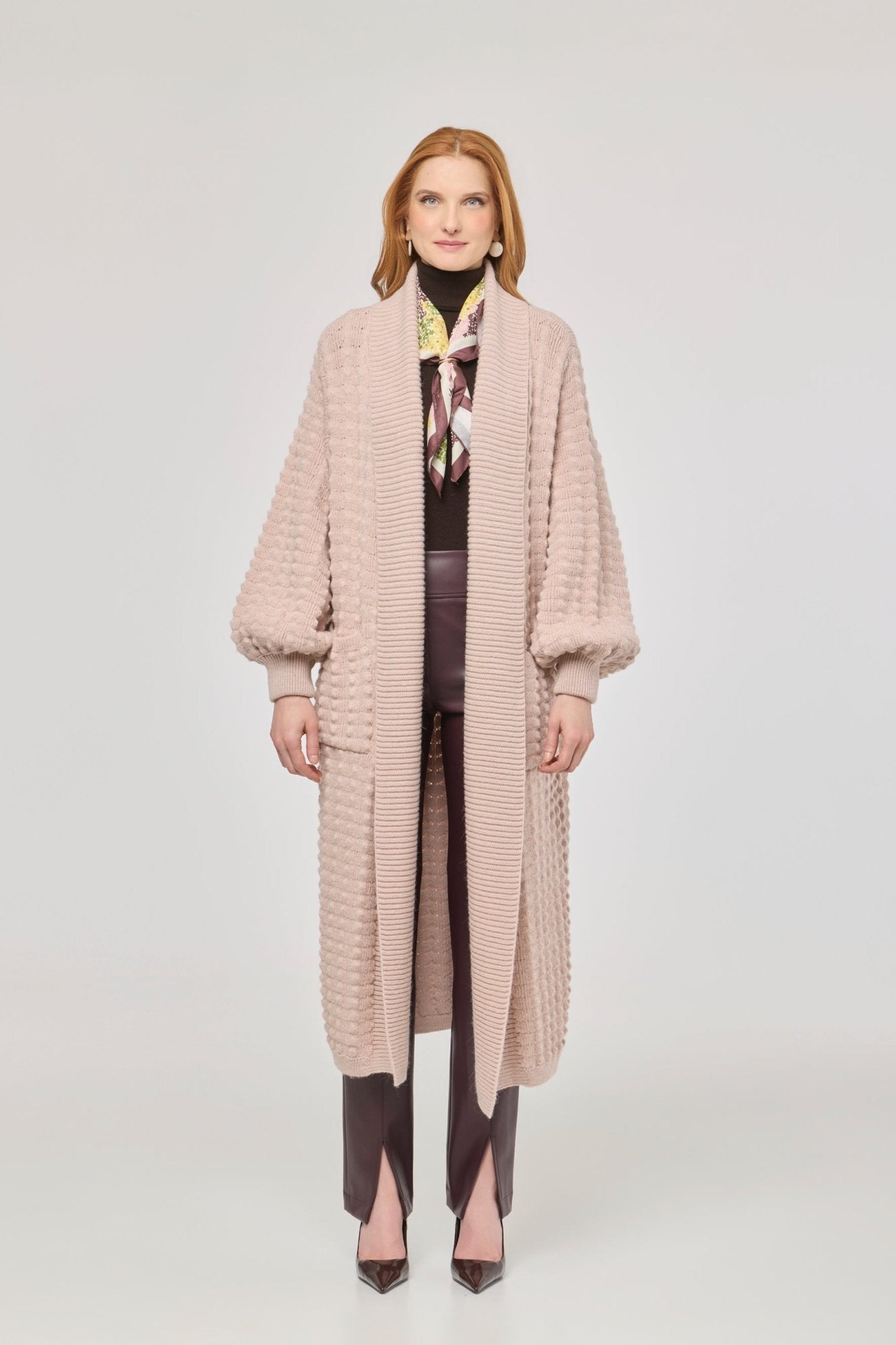 Cárdigan largo rosa de punto para mujer con mangas de textura geométrica y diseño minimalista.