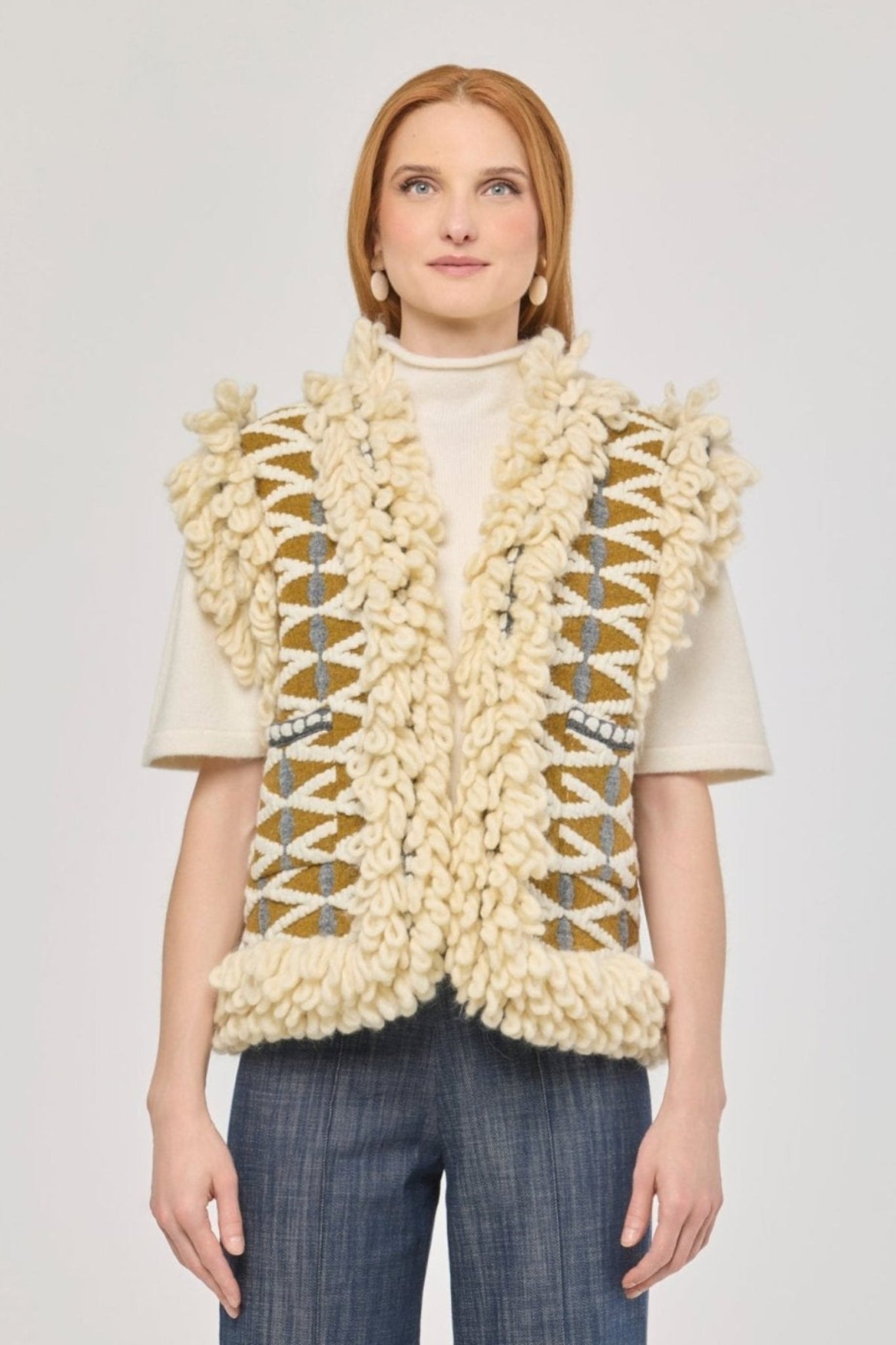 Chaleco de punto con flecos Brittany, diseño geométrico en tonos crudo y mostaza con acabado artesanal.