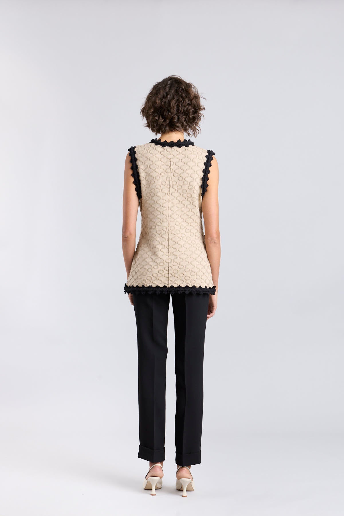 Chaleco de punto para mujer modelo Tristan en tono arena con bordados negros en relieve.