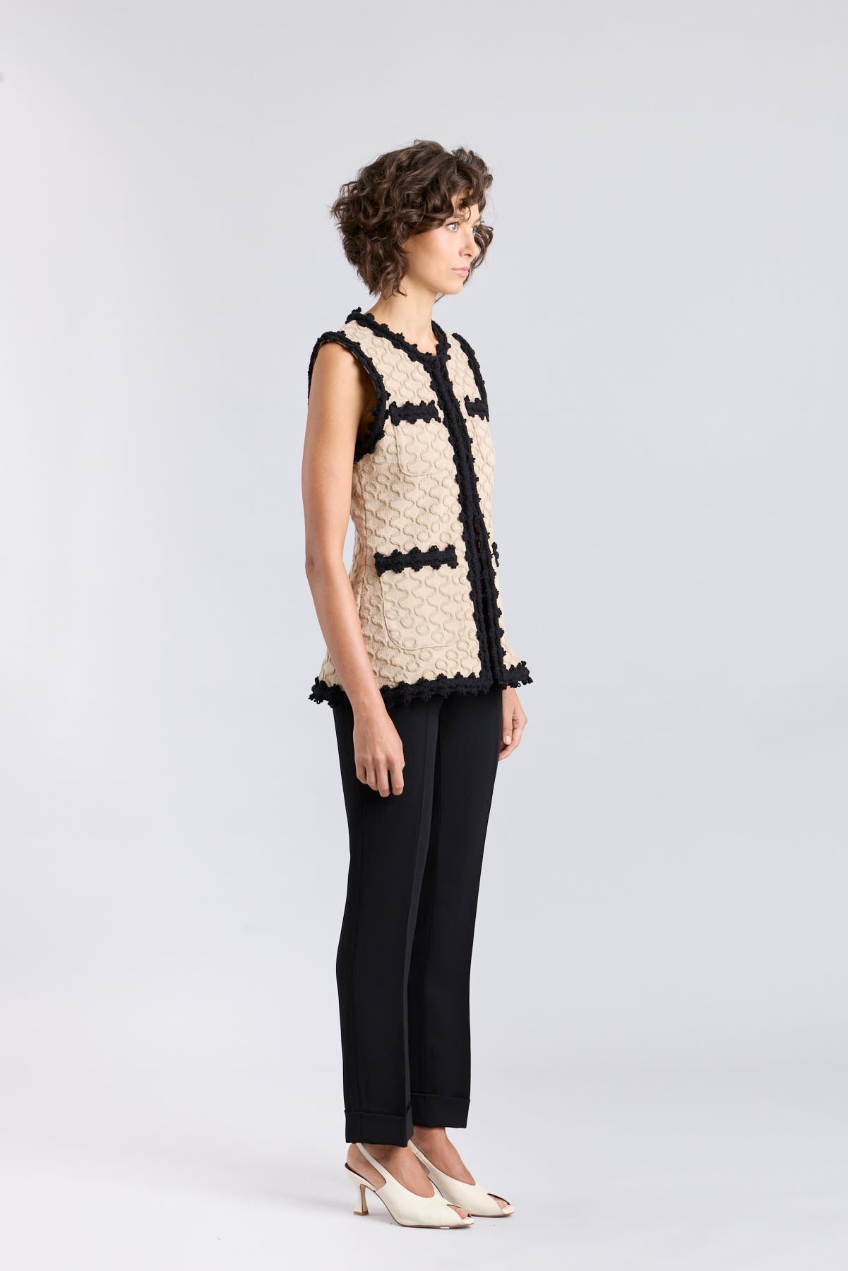 Chaleco de punto para mujer modelo Tristan en tono arena con bordados negros en relieve.