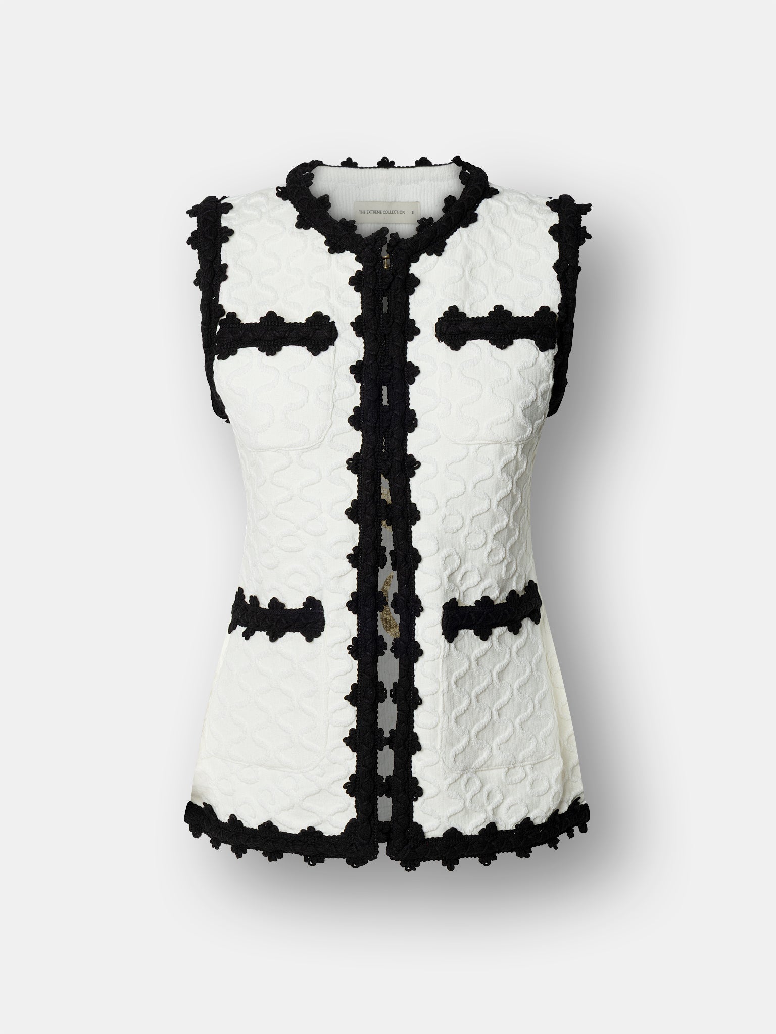 Chaleco de lujo blanco para mujer modelo Tristan con perfiles festoneados en negro.