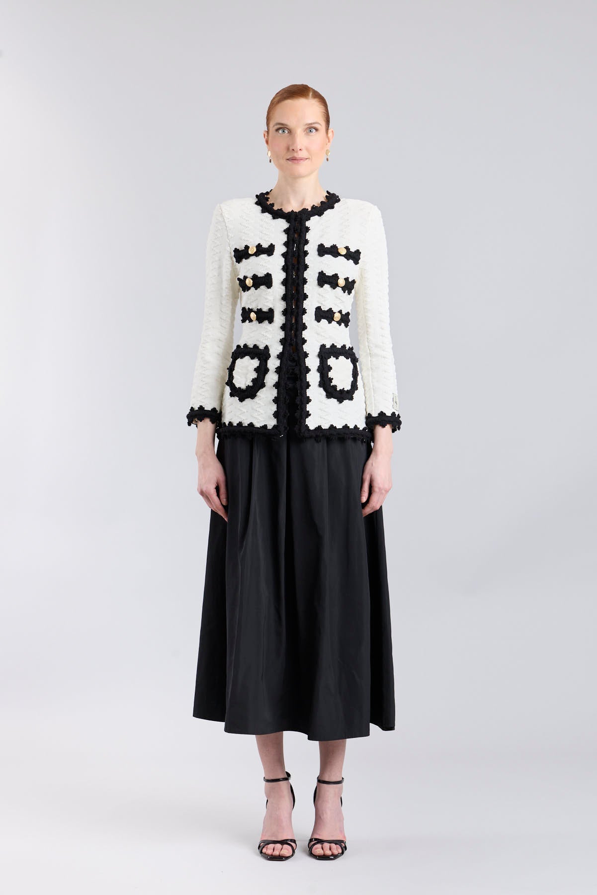 Chaqueta de punto para mujer modelo Oliver en blanco con vivos y bolsillos en negro.