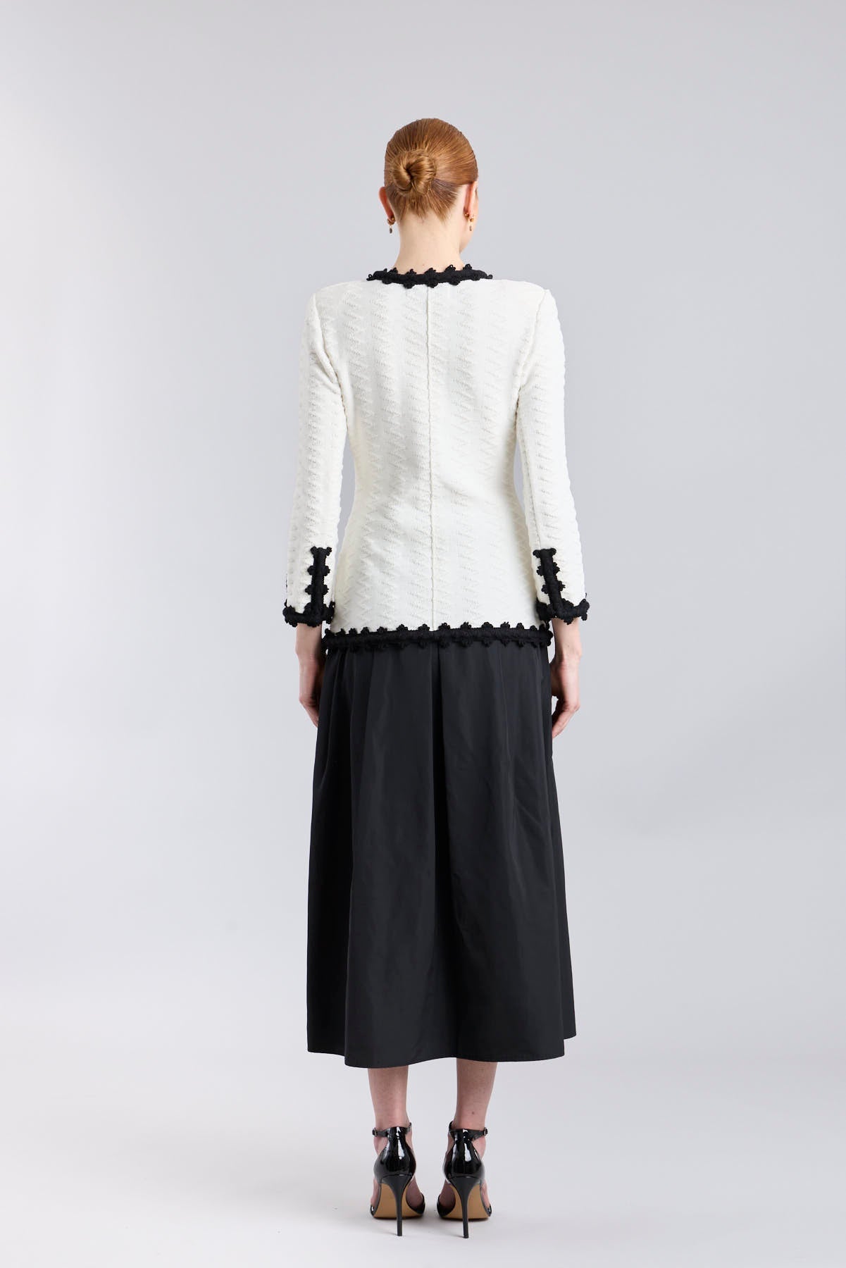 Chaqueta de punto para mujer modelo Oliver en blanco con vivos y bolsillos en negro.