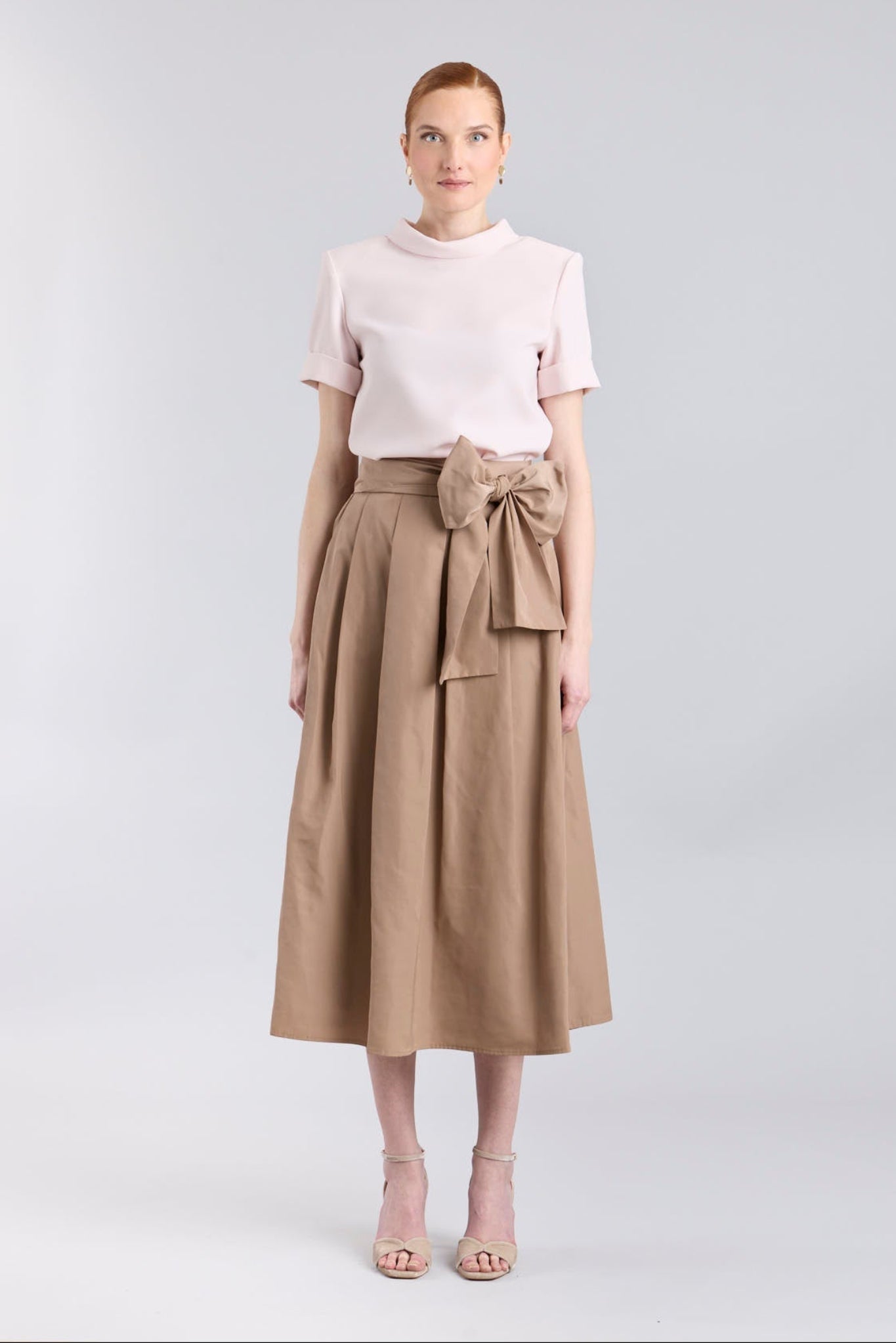 Falda midi color camel con volumen y detalle de lazo en la cintura de The Extreme Collection.