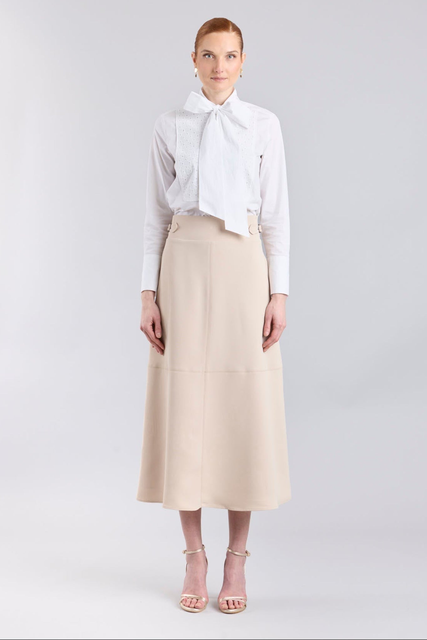 Falda midi de corte evasé color beige con detalle de hebillas en la cintura de The Extreme Collection.