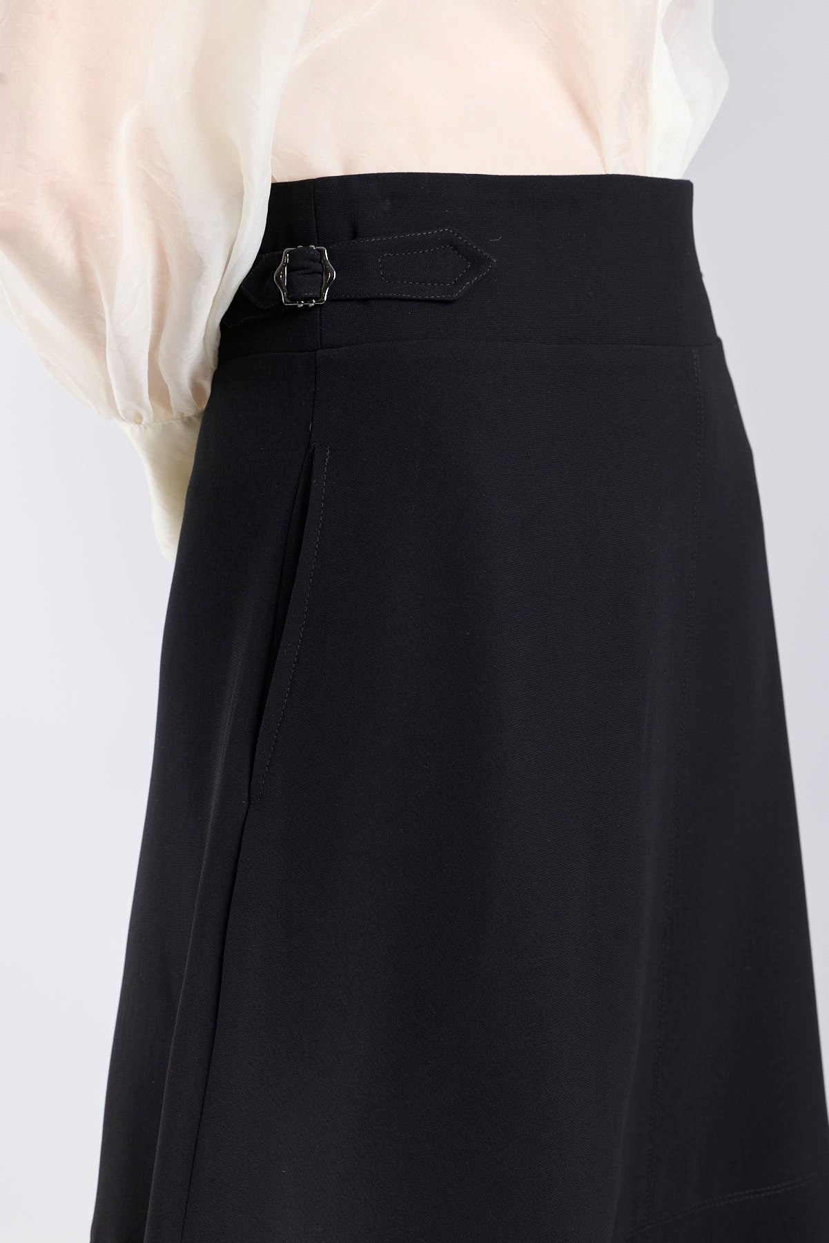 Falda midi de corte evasé color negro con detalle de hebillas en la cintura de The Extreme Collection.