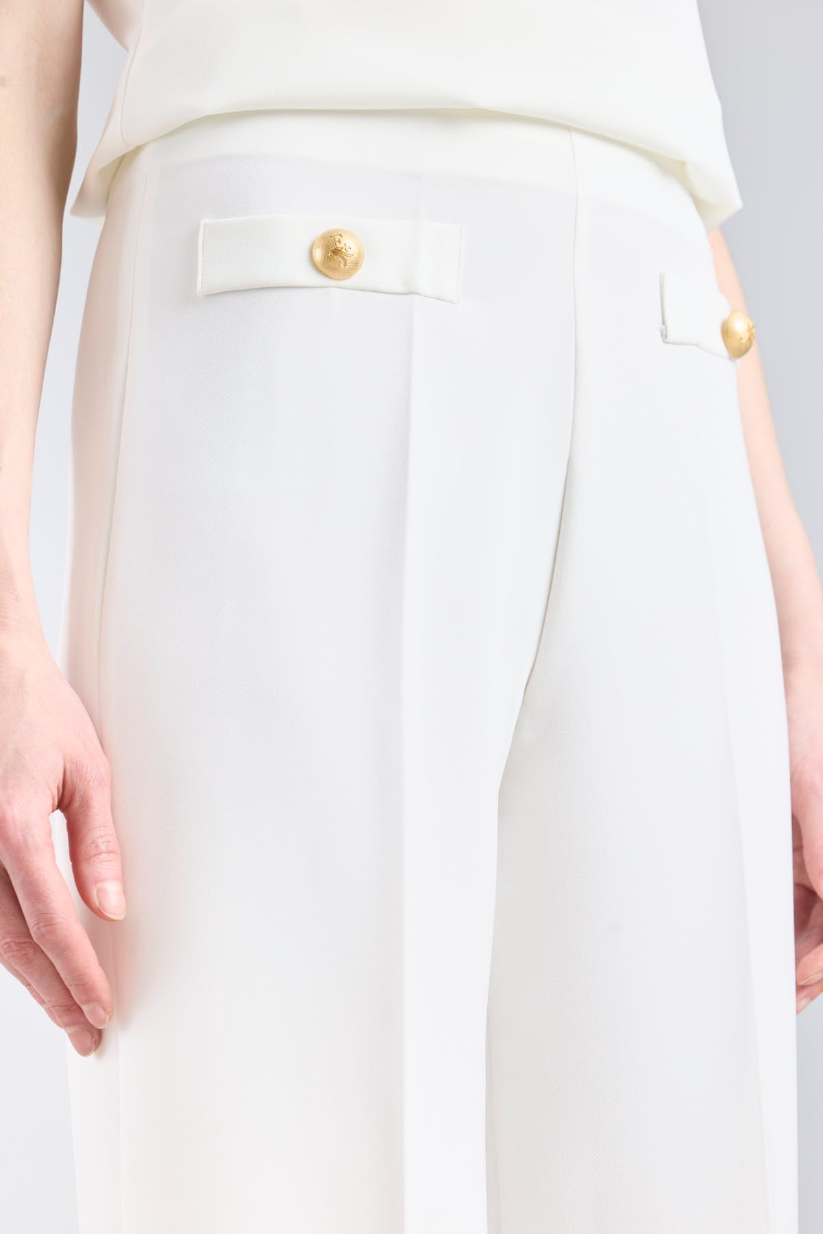 Pantalón blanco de tiro alto estilo palazzo con botones dorados de The Extreme Collection.