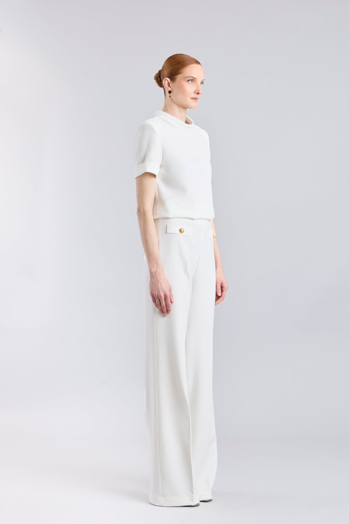 Pantalón blanco de tiro alto estilo palazzo con botones dorados de The Extreme Collection.