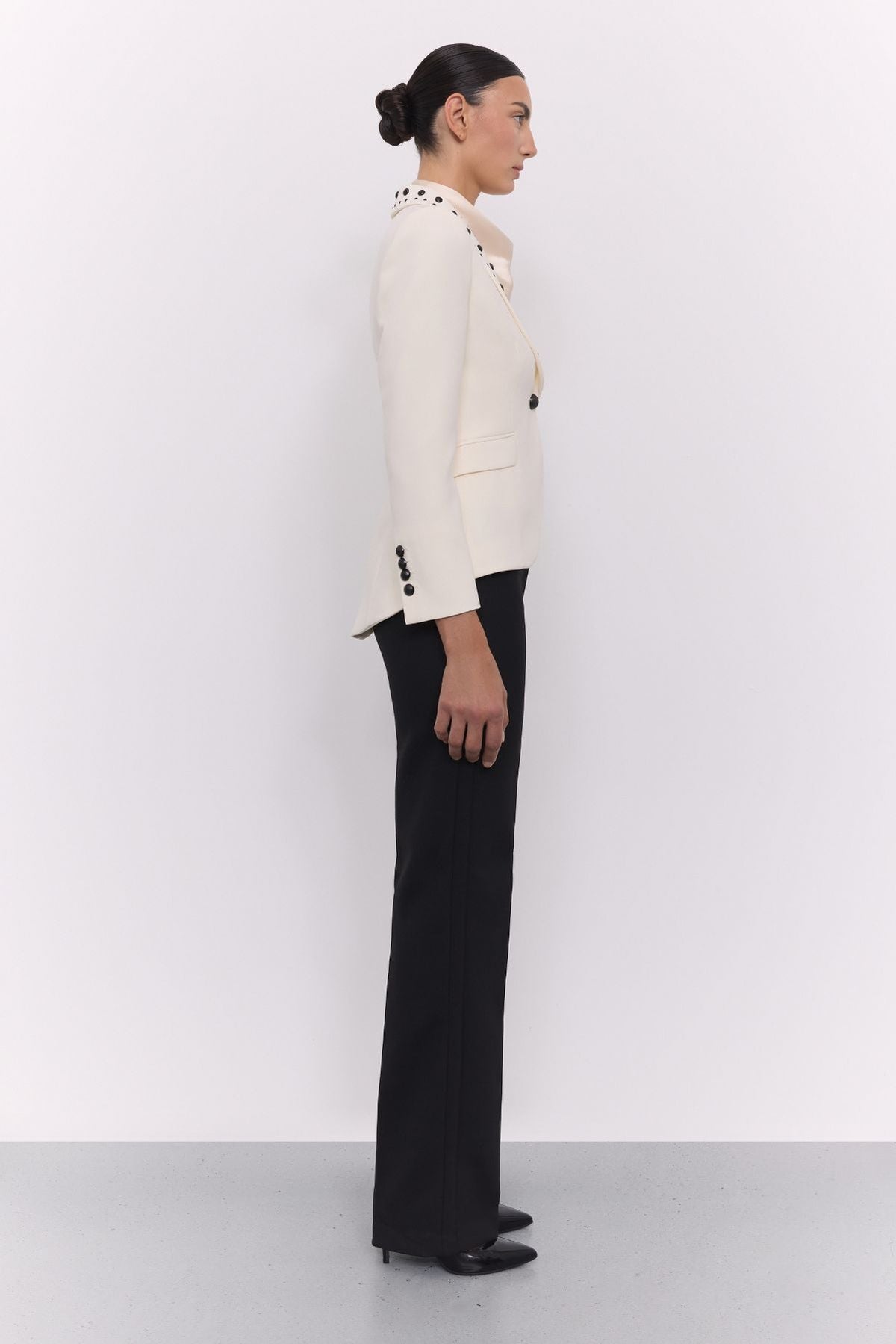 Blazer tachas marfil Eleanore en super crepe color marfil con solapa smoking, detalles de tachas negras colocadas a mano.