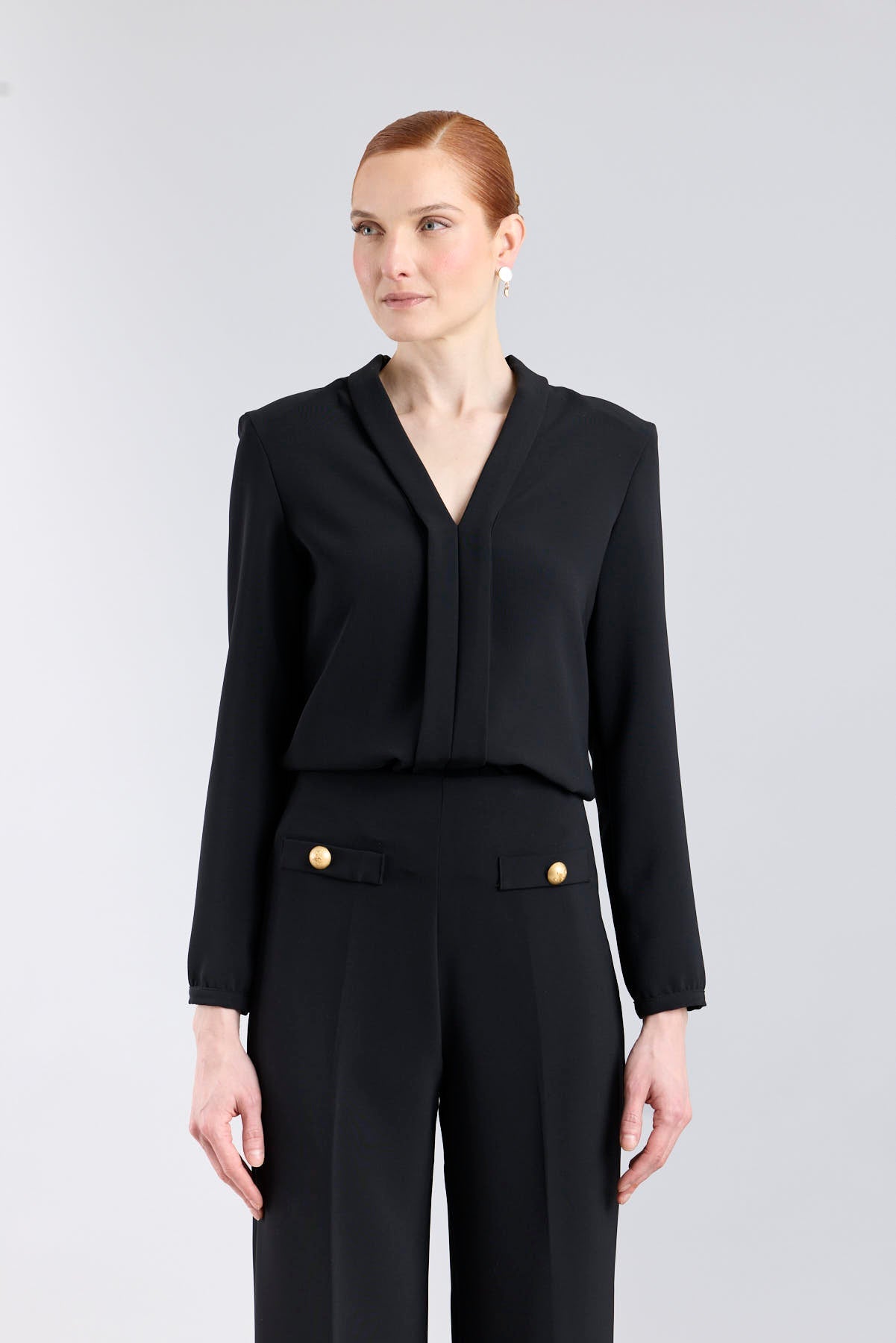 Blusa negra con cuello tipo esmoquin de The Extreme Collection.