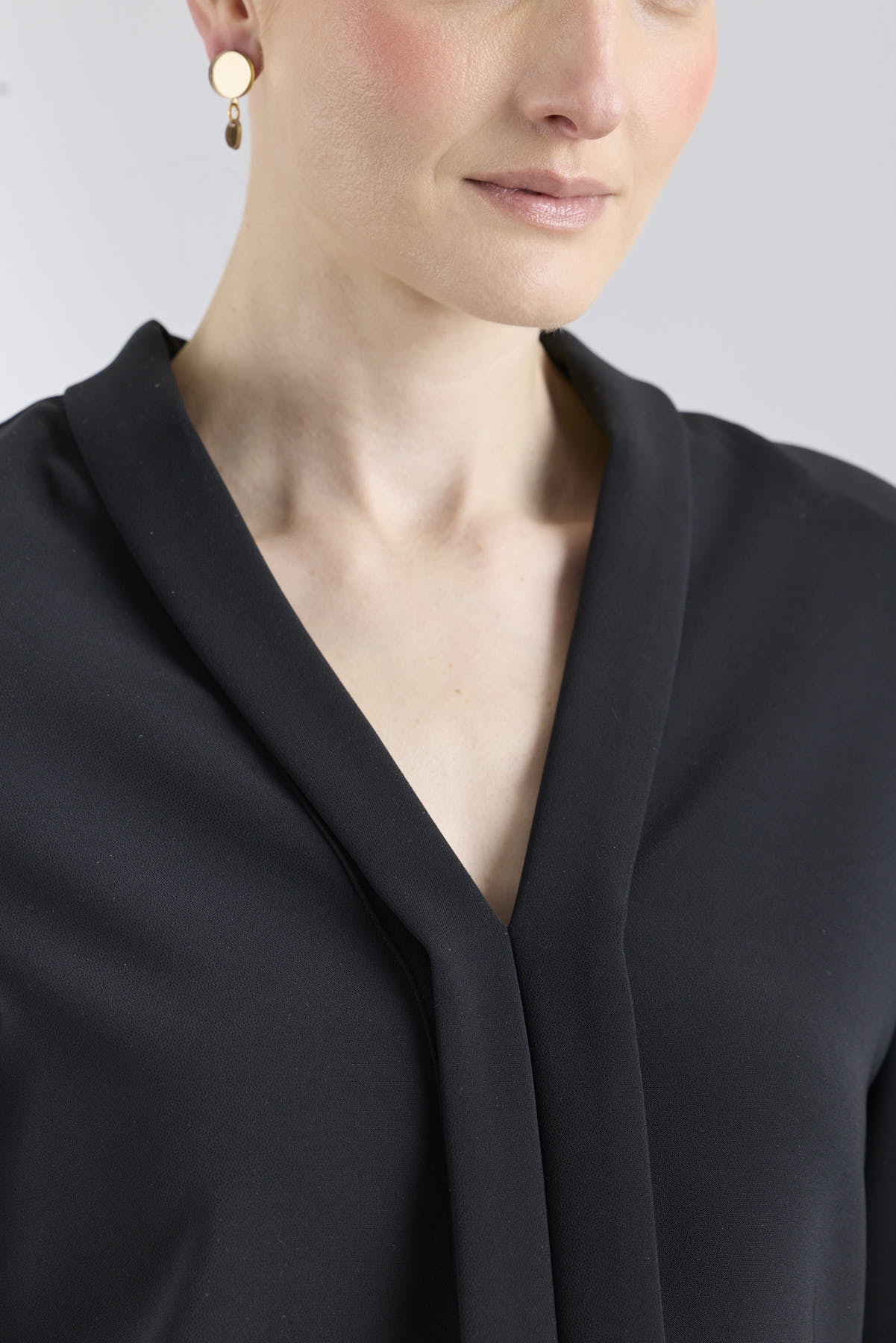 Blusa negra con cuello tipo esmoquin de The Extreme Collection.