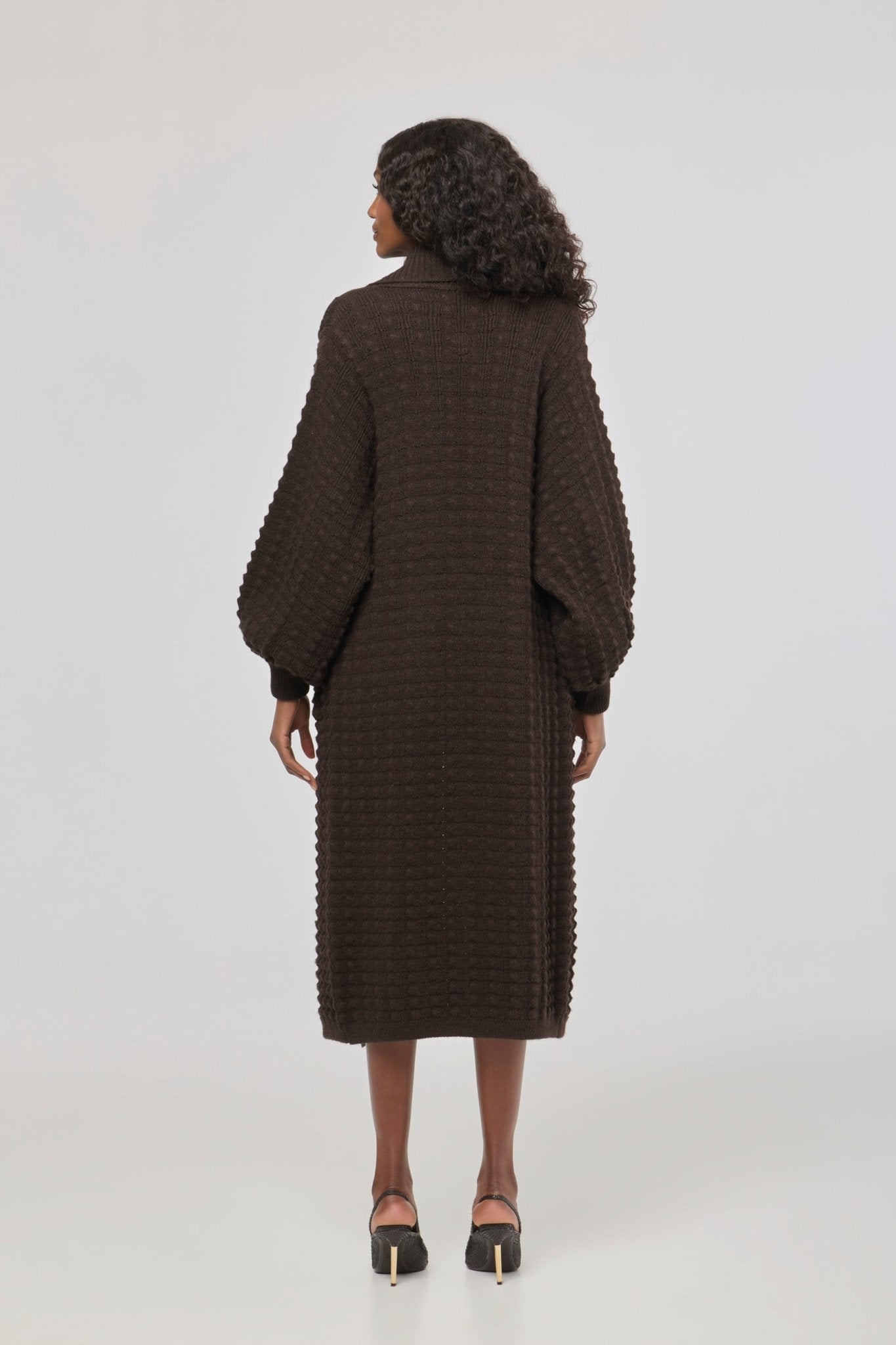 Cárdigan largo marrón de punto para mujer con mangas de textura geométrica y diseño minimalista.