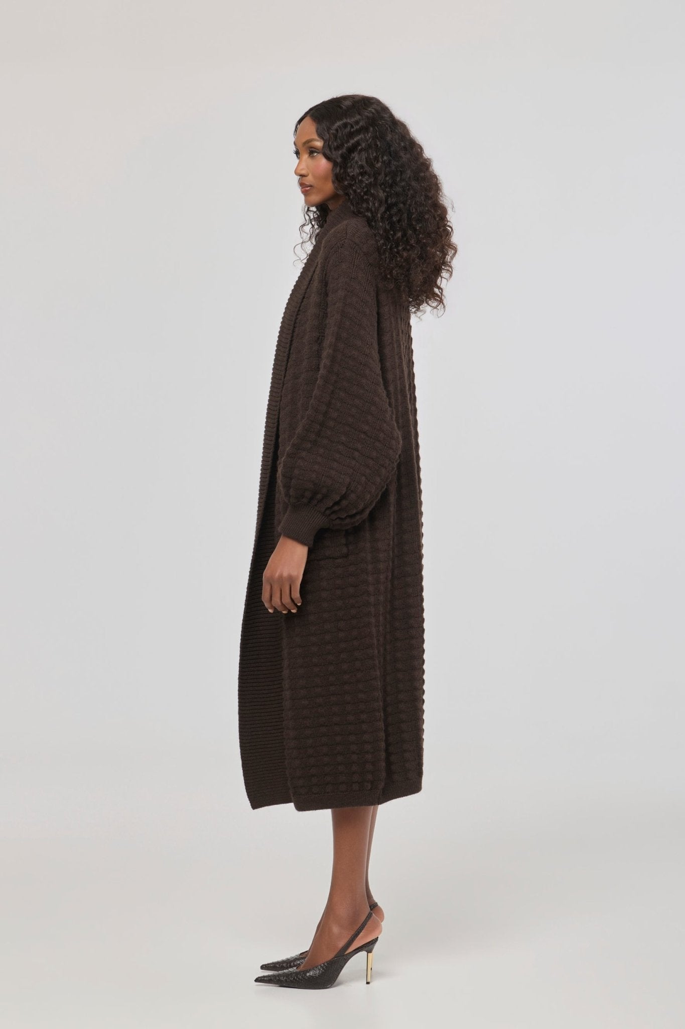 Cárdigan largo marrón de punto para mujer con mangas de textura geométrica y diseño minimalista.
