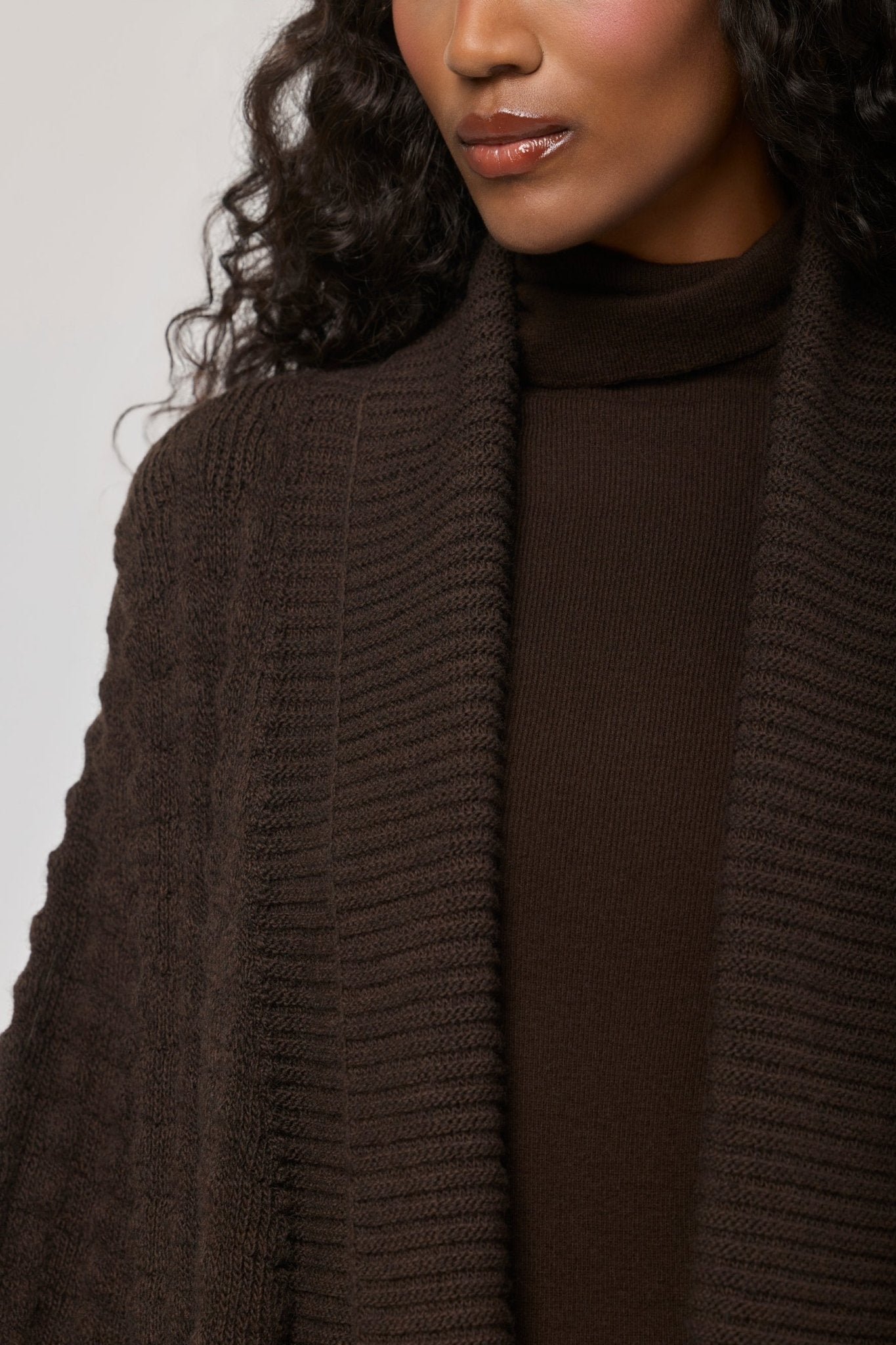Cárdigan largo marrón de punto para mujer con mangas de textura geométrica y diseño minimalista.