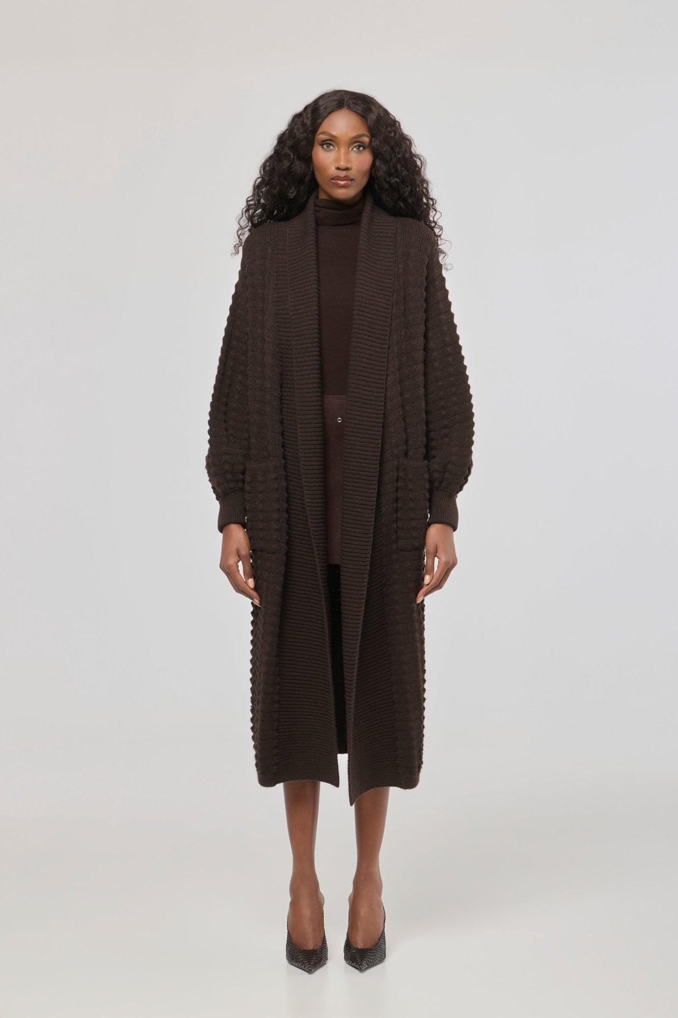 Cárdigan largo marrón de punto para mujer con mangas de textura geométrica y diseño minimalista.