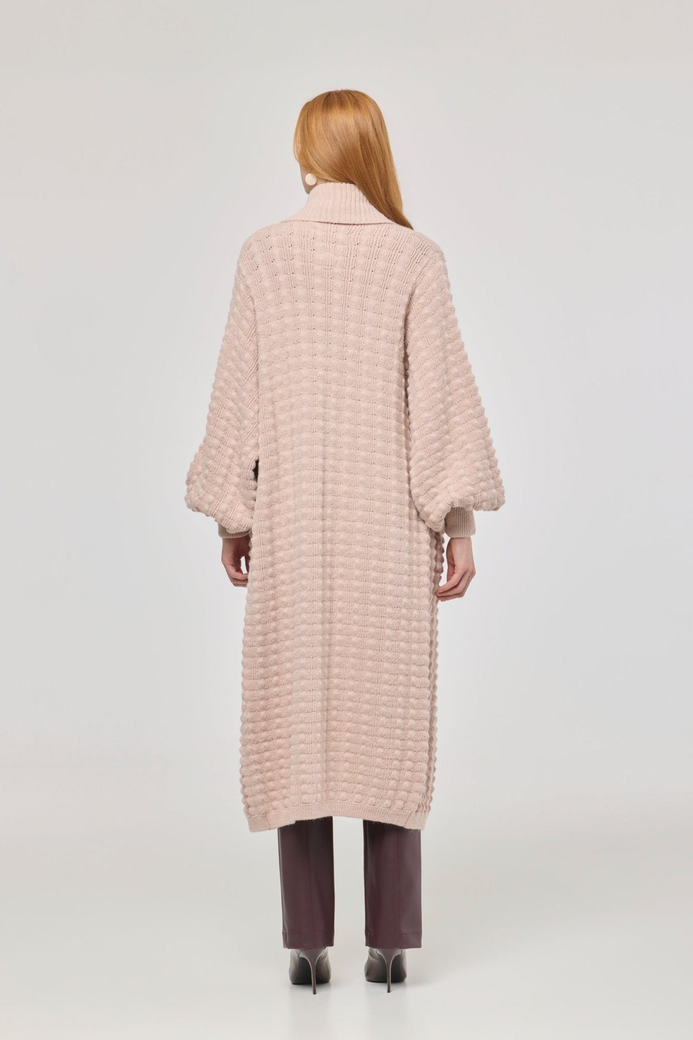Cárdigan largo rosa de punto para mujer con mangas de textura geométrica y diseño minimalista.