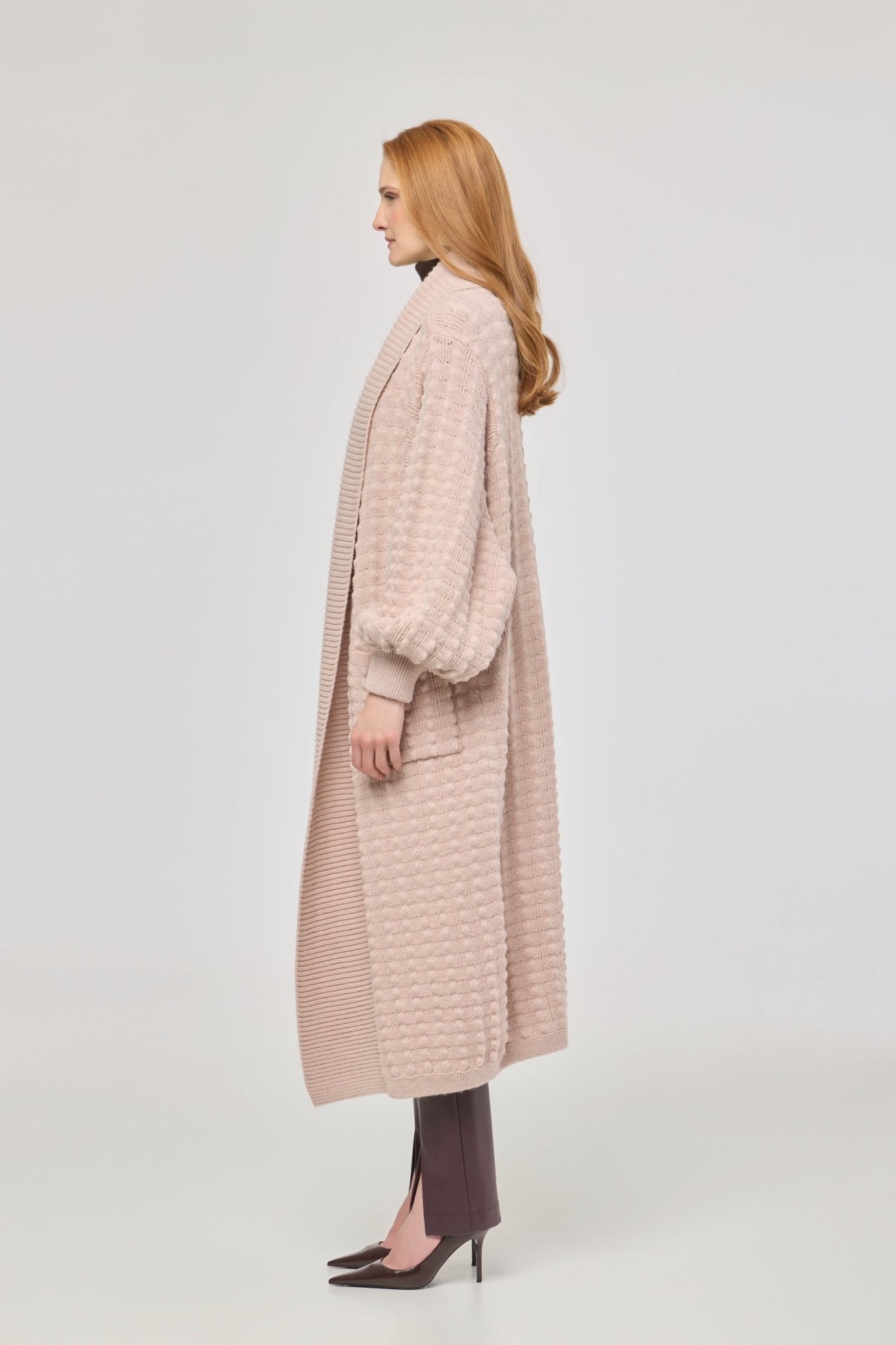 Cárdigan largo rosa de punto para mujer con mangas de textura geométrica y diseño minimalista.