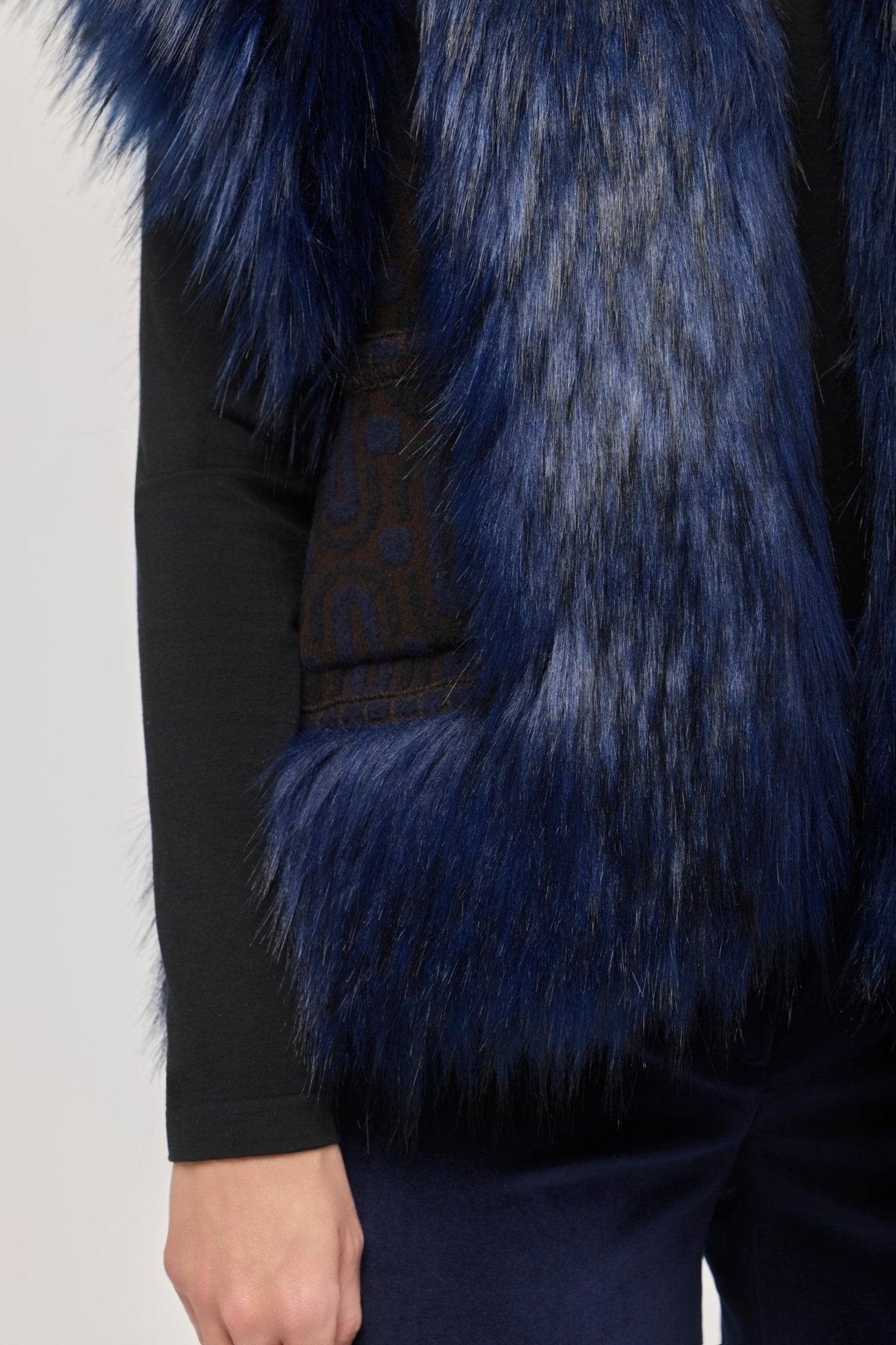 Chaleco punto pelo modelo Theodoro, con base de jacquard geométrico en tono azul y aplicaciones de pelo de alta densidad.