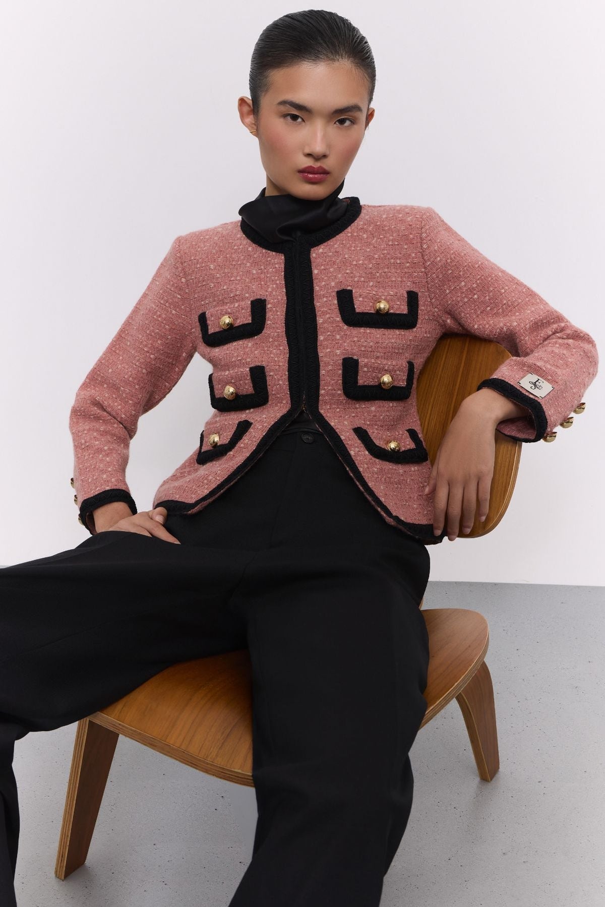 Chaqueta corta de punto rosa para mujer Preston, con ribetes negros en contraste y botones dorados.
