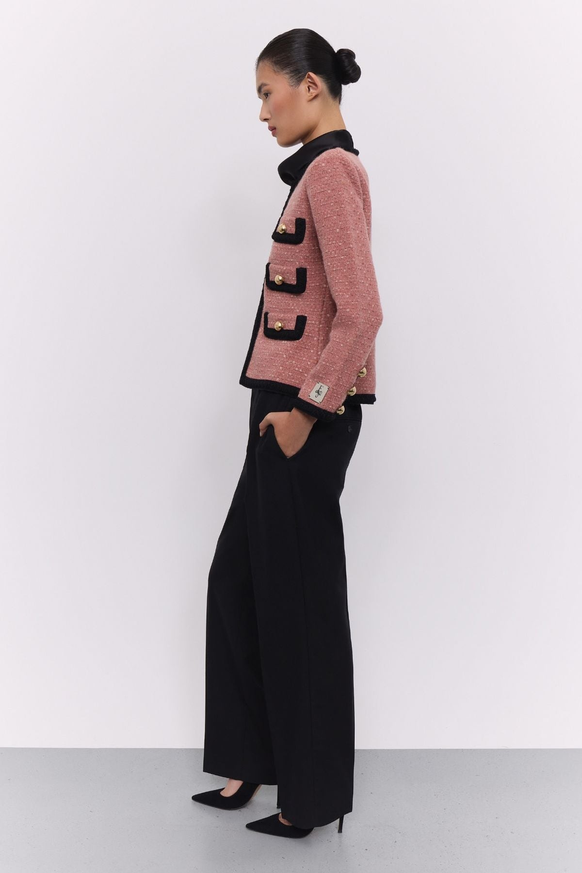 Chaqueta corta de punto rosa para mujer Preston, con ribetes negros en contraste y botones dorados.