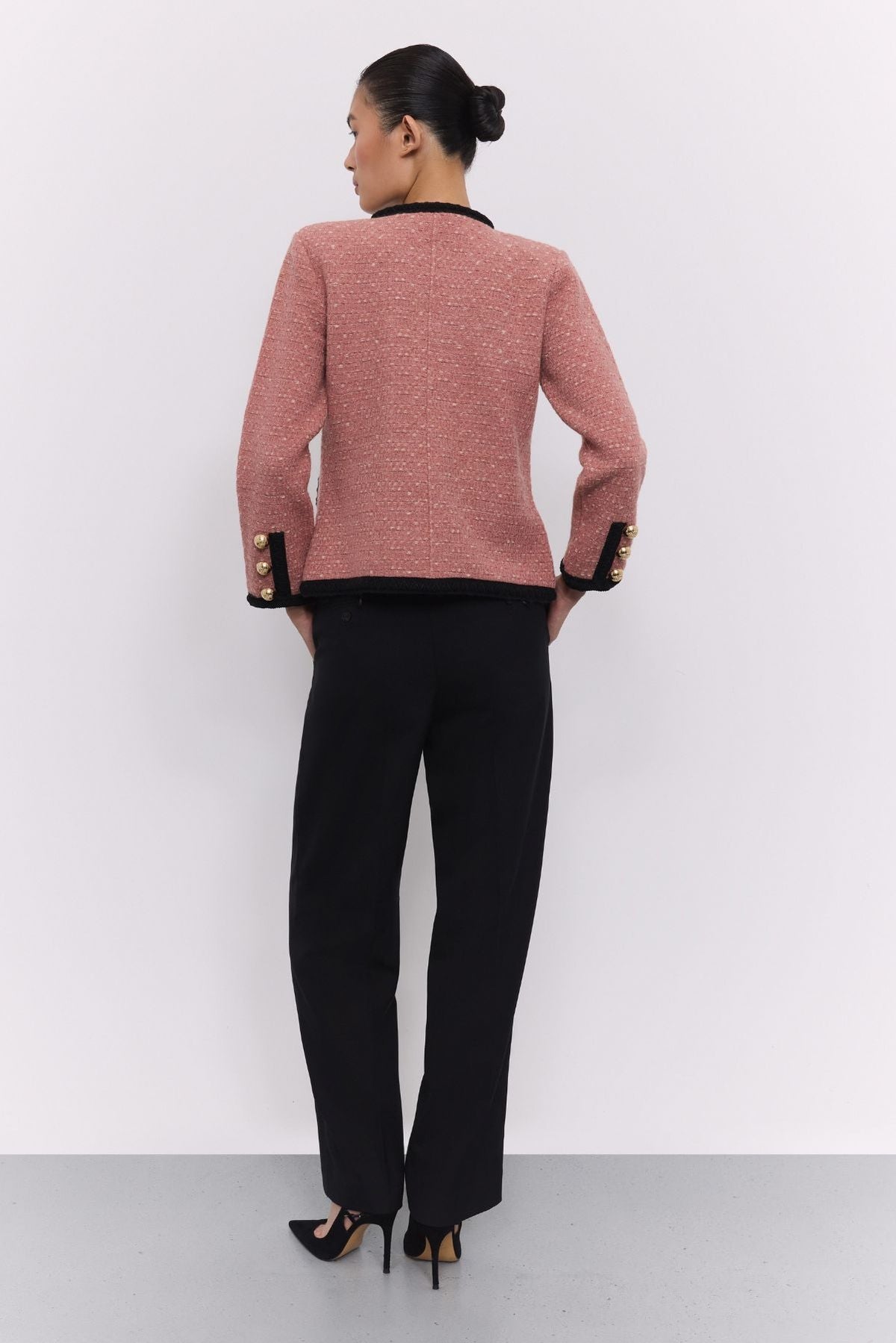Chaqueta corta de punto rosa para mujer Preston, con ribetes negros en contraste y botones dorados.