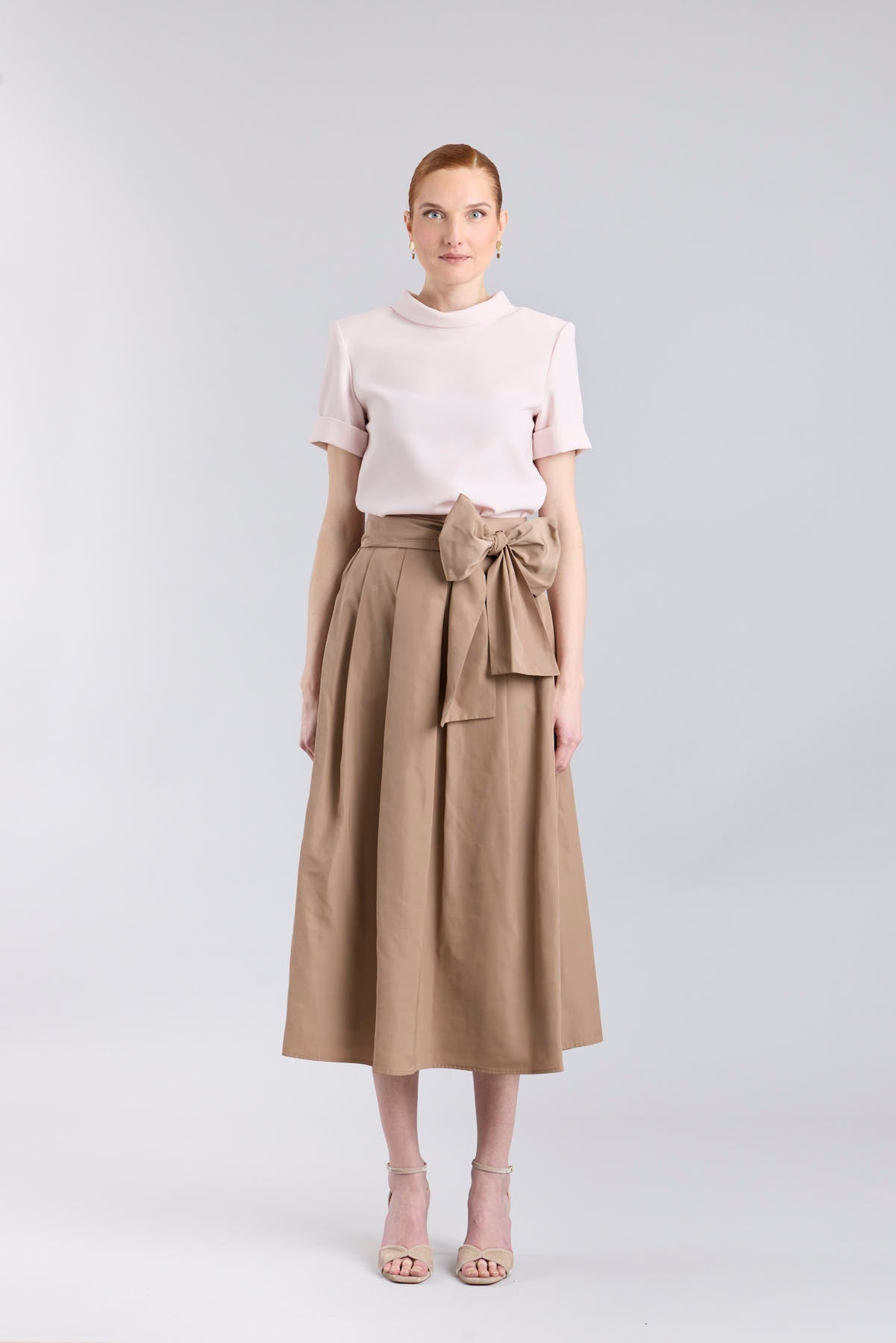 Falda midi color camel con volumen y detalle de lazo en la cintura de The Extreme Collection.