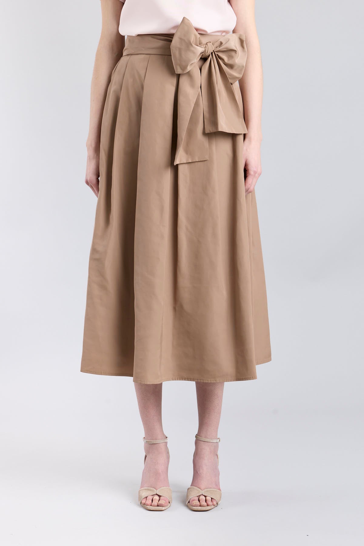 Falda midi color camel con volumen y detalle de lazo en la cintura de The Extreme Collection.