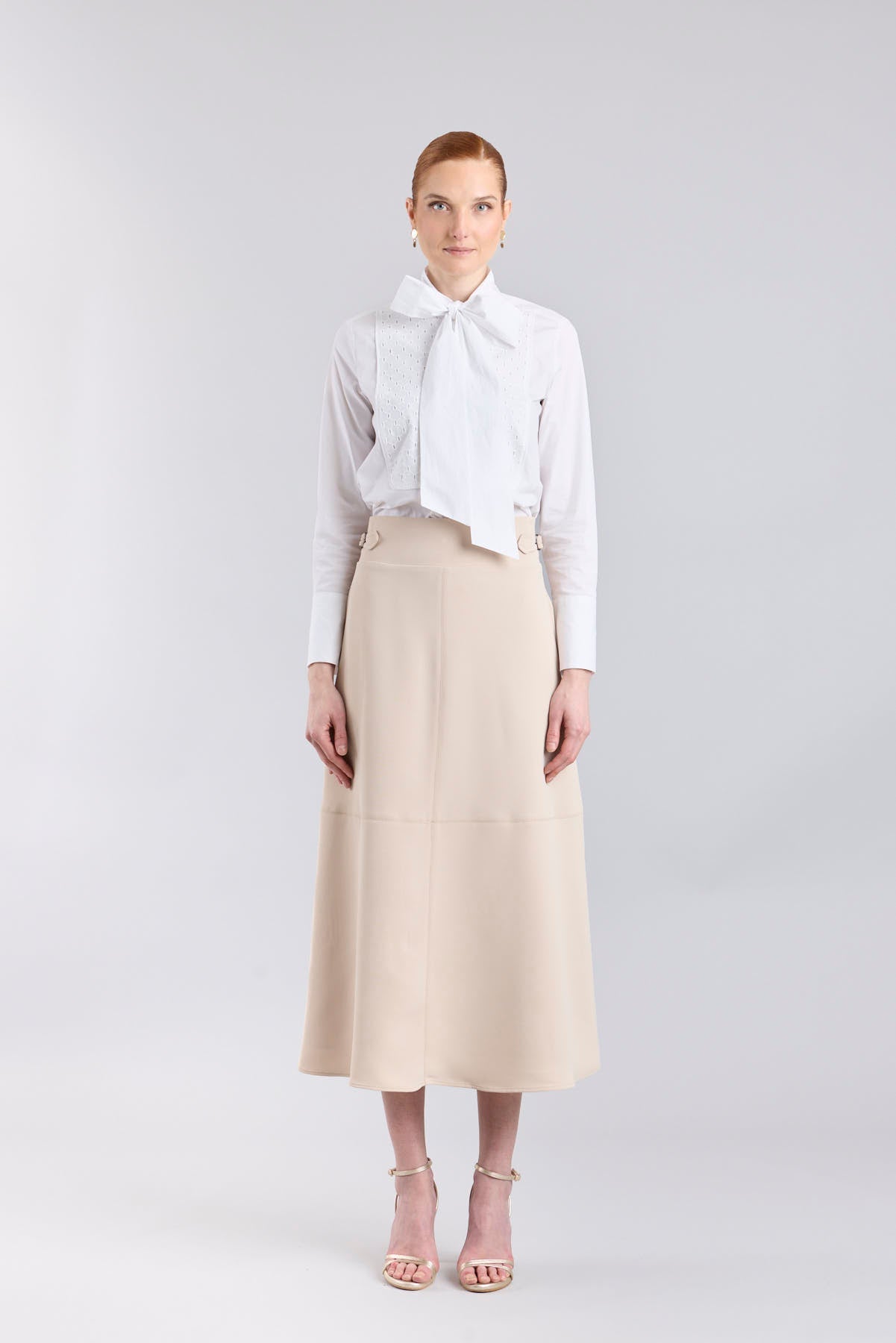 Falda midi de corte evasé color beige con detalle de hebillas en la cintura de The Extreme Collection.