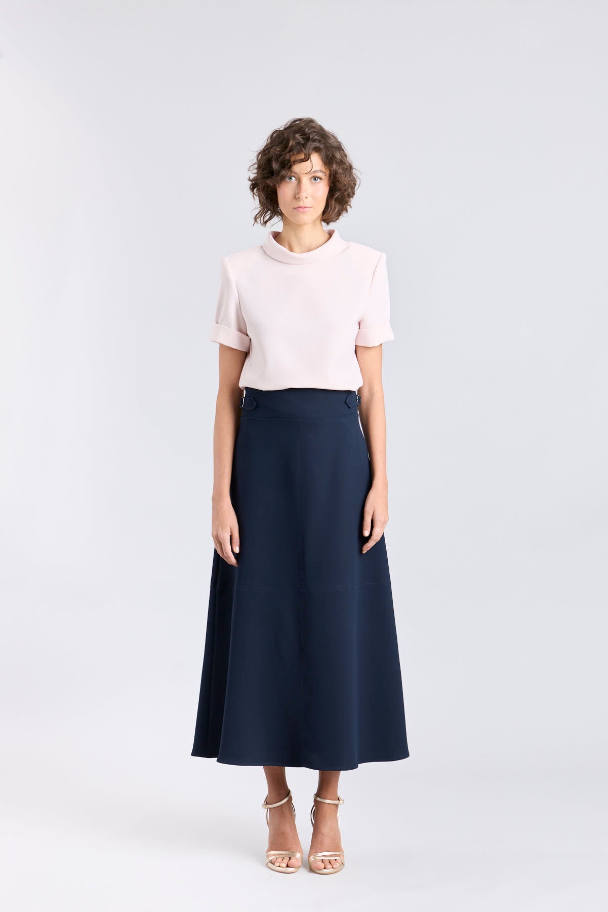 Falda midi de corte evasé color azul marino con detalle de hebillas en la cintura de The Extreme Collection.