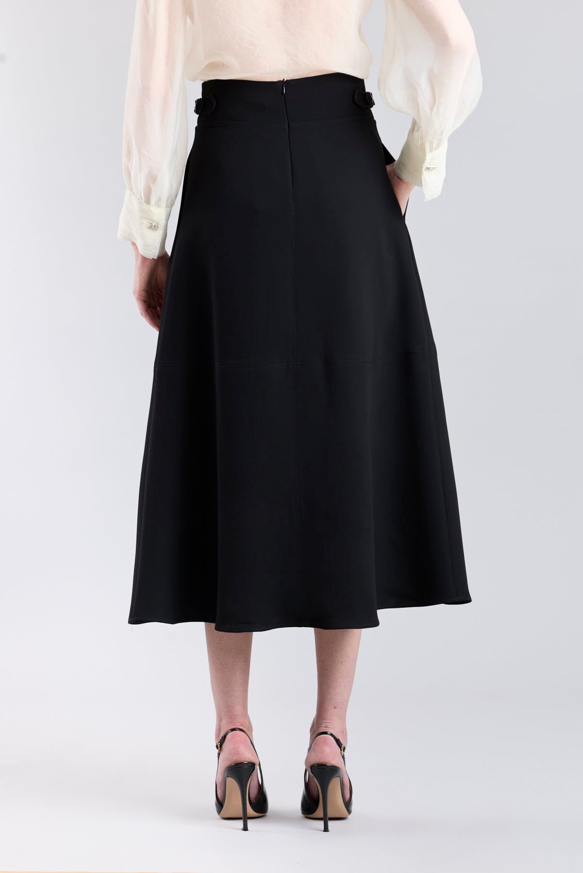 Falda midi de corte evasé color negro con detalle de hebillas en la cintura de The Extreme Collection.