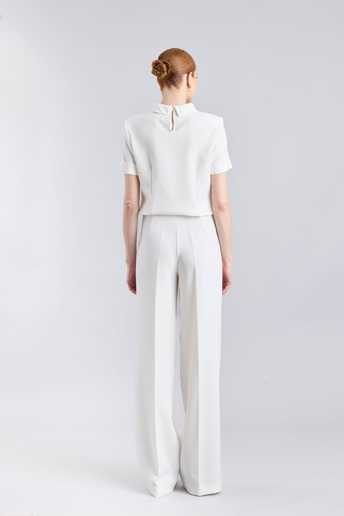 Pantalón blanco de tiro alto estilo palazzo con botones dorados de The Extreme Collection.