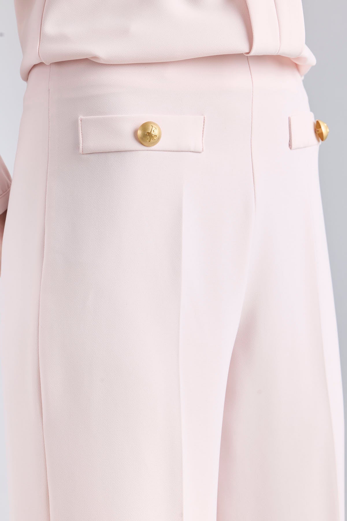 Pantalón rosa de tiro alto estilo palazzo con botones dorados de The Extreme Collection.